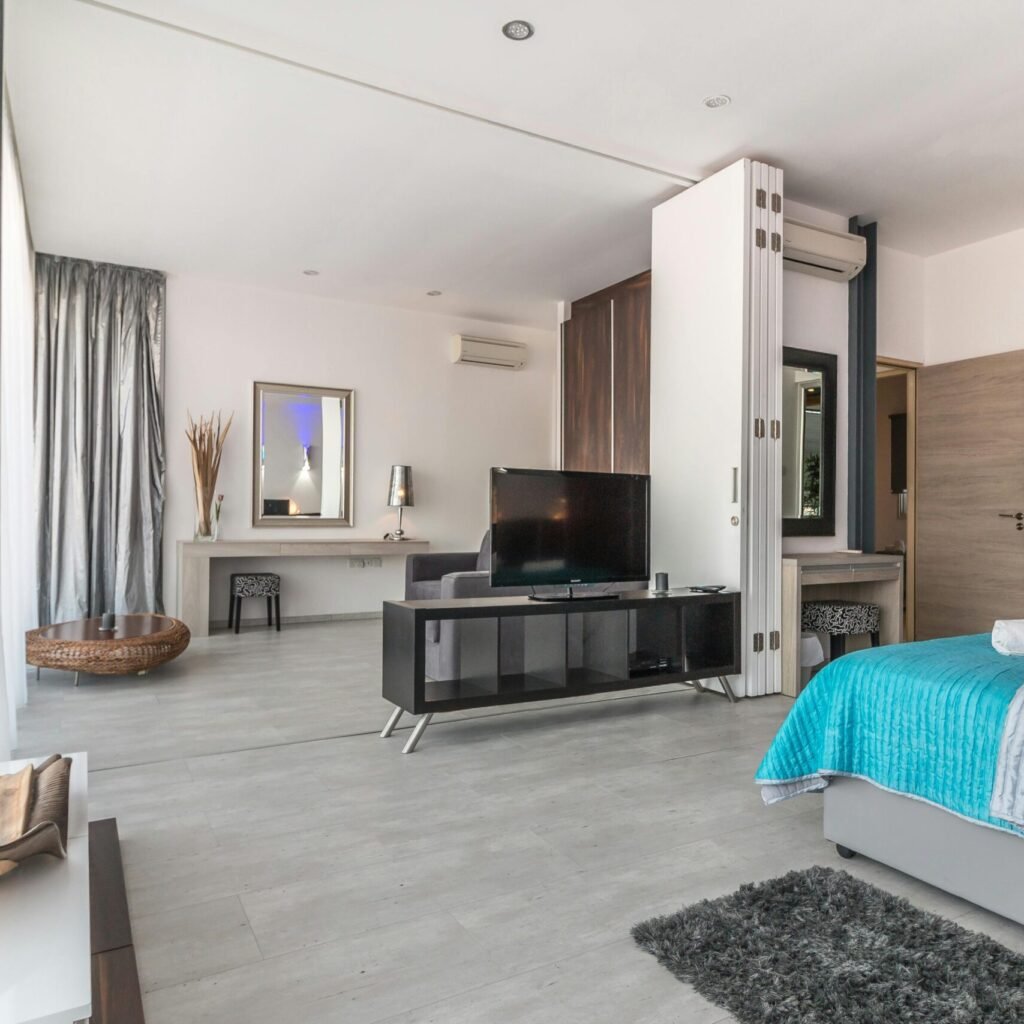 Spacious and modern bedroom with sleek design, featuring elegant decor and natural lighting.